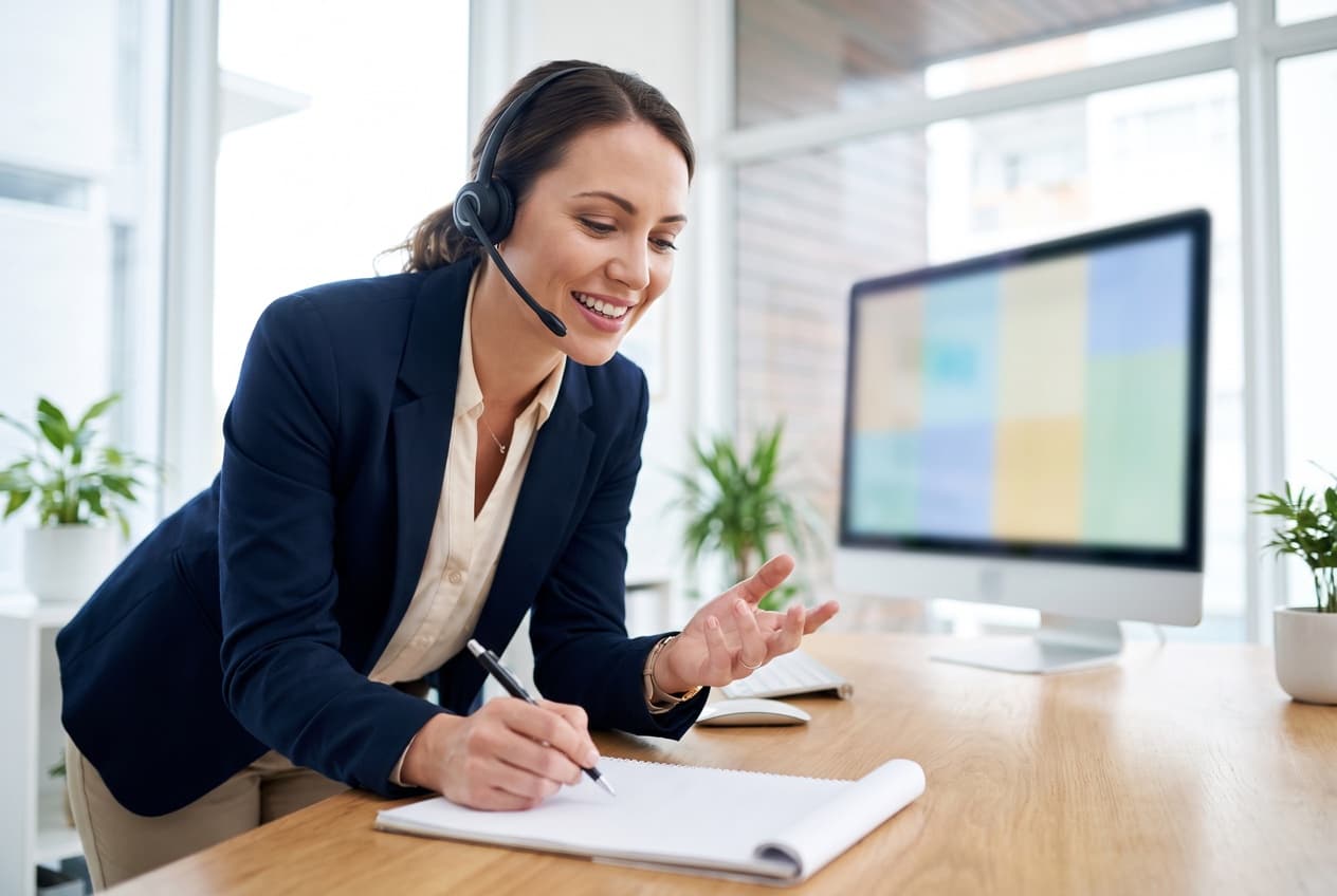 Commerciale avec un casque audio prenant des notes pendant un appel de qualification, l'étape qui décide de la valeur réelle d'un prospect généré par LinkedIn Ads